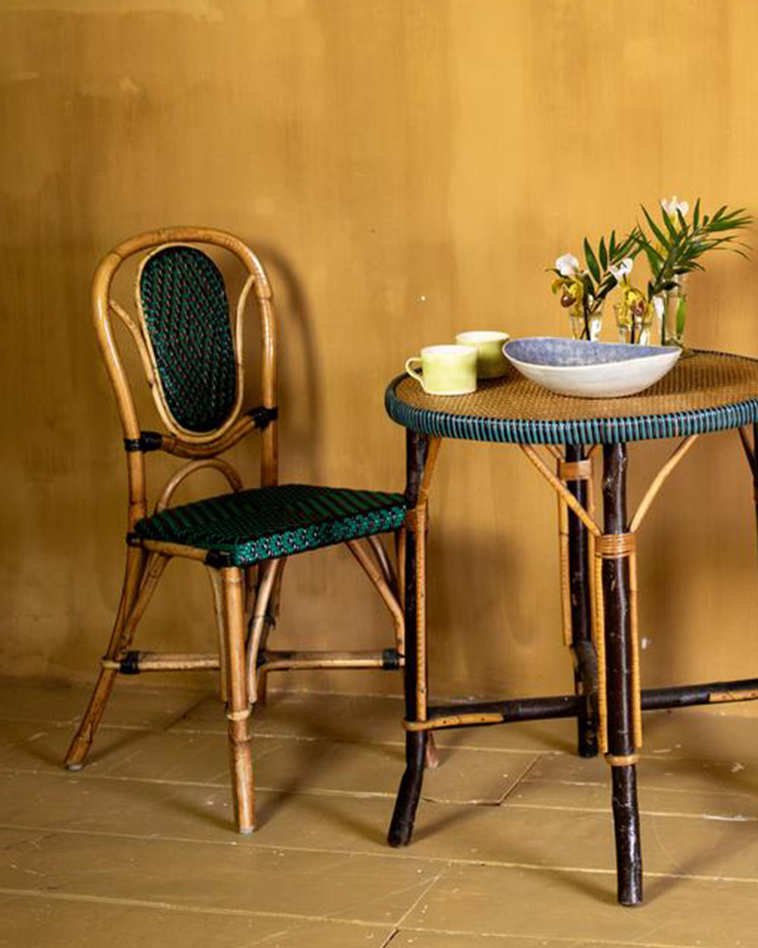 Set of wicker table and two green wicker chairs